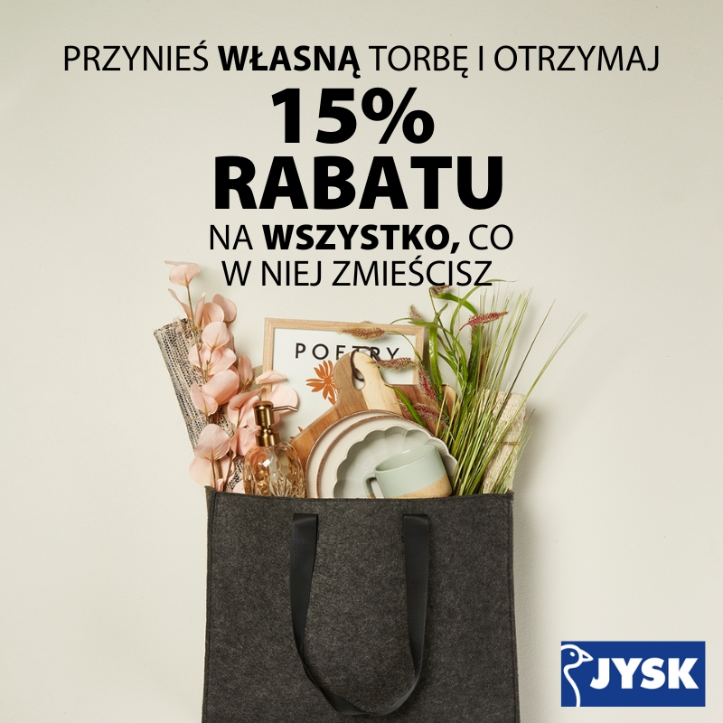 Grafika promocyjna sieci JYSK. Na jasnym tle widoczna jest duża, szara torba z filcu wypełniona artykułami dekoracyjnymi, takimi jak ramka na zdjęcia, talerze, kubek, butelka z dozownikiem oraz sztuczne rośliny. Powyżej torby znajduje się napis: „PRZYNIEŚ WŁASNĄ TORBĘ I OTRZYMAJ 15% RABATU NA WSZYSTKO, CO W NIEJ ZMIEŚCISZ”. W prawym dolnym rogu umieszczono niebieskie logo JYSK.