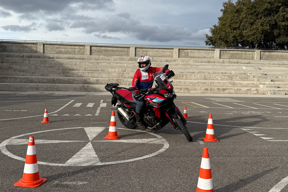 Wydarzenie motocyklowe w M1 Łódź. Mężczyzna na motorze pokonujący tor przeszkód na parkingu.